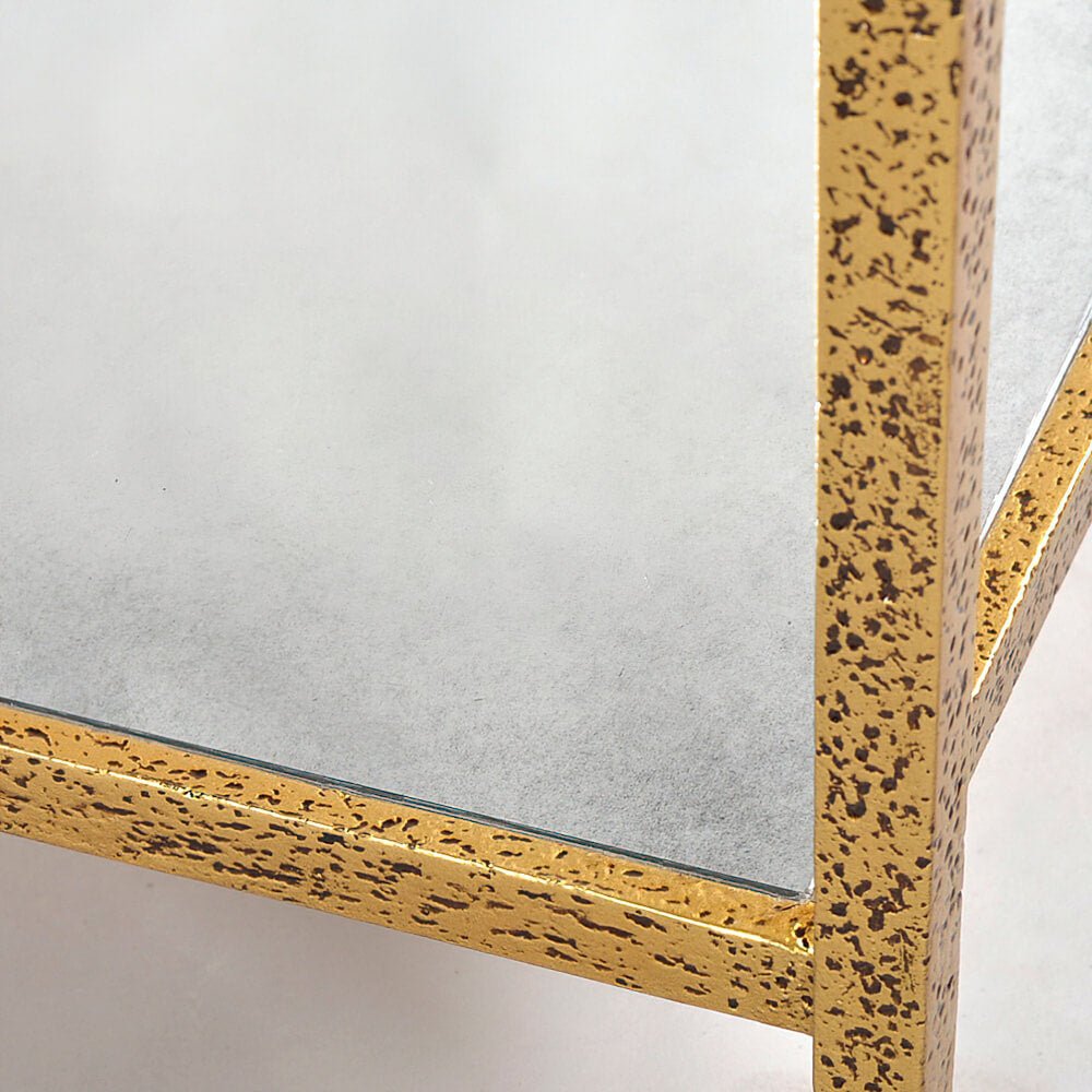 Detailed side view of glass top and gold frame.