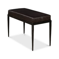 Side perspective of black leather bench with iron legs.
