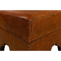 Close-up of ottoman's corner leather stitching and rivets.
