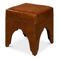 Brown leather ottoman with detailed arching base design.