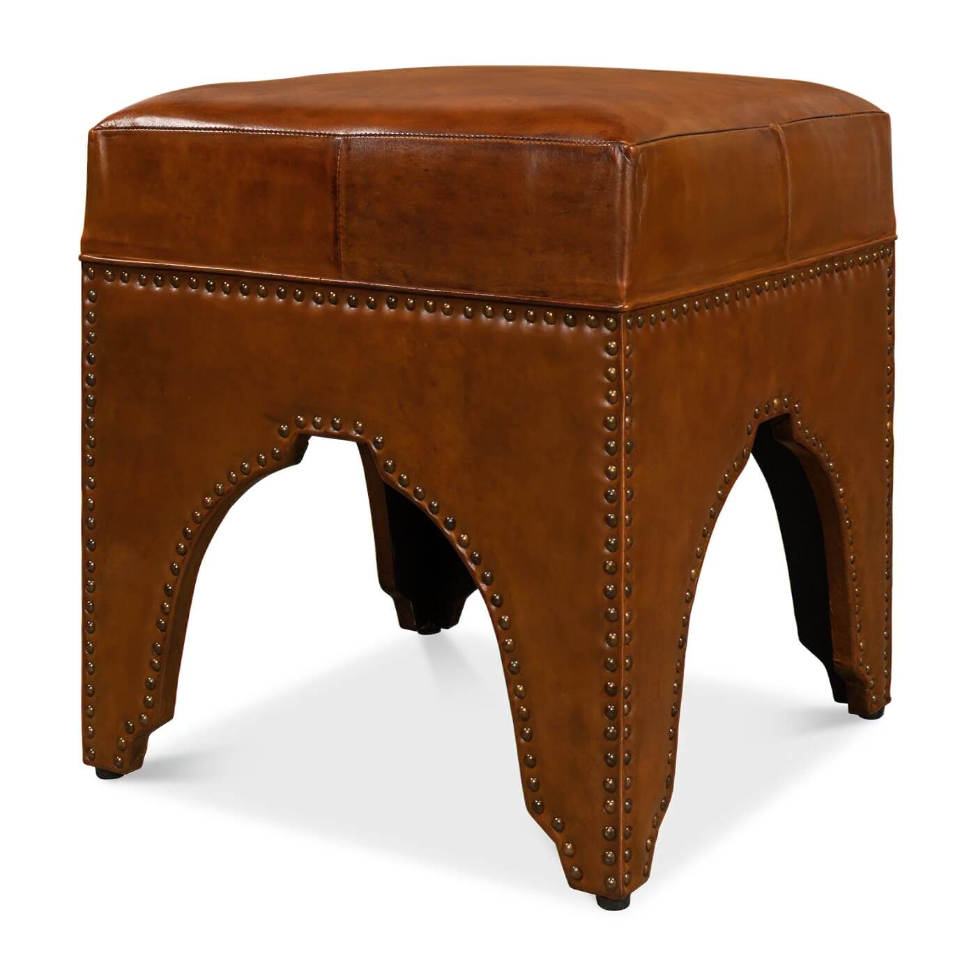 Angled view of leather ottoman, rivet-studded arch base.
