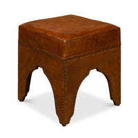 Brown ottoman with distinctive arch base, side view.