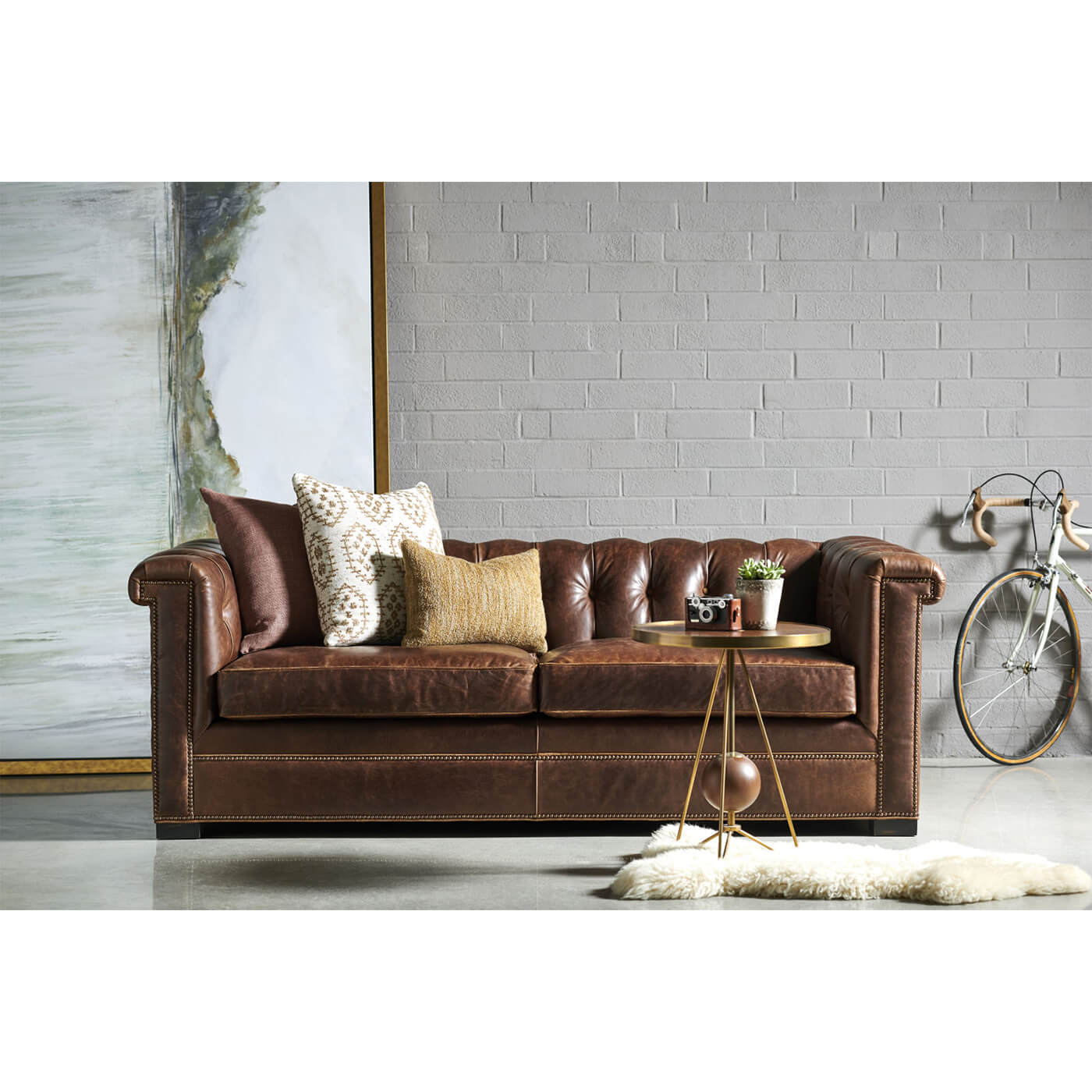 Brown leather Chesterfield sofa in styled room setting
