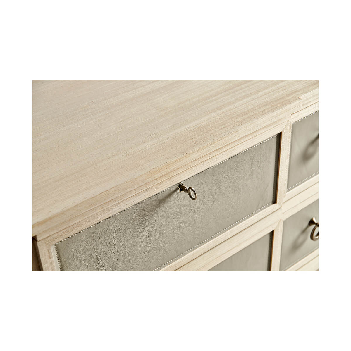 Beige chest of drawers, top corner detail.