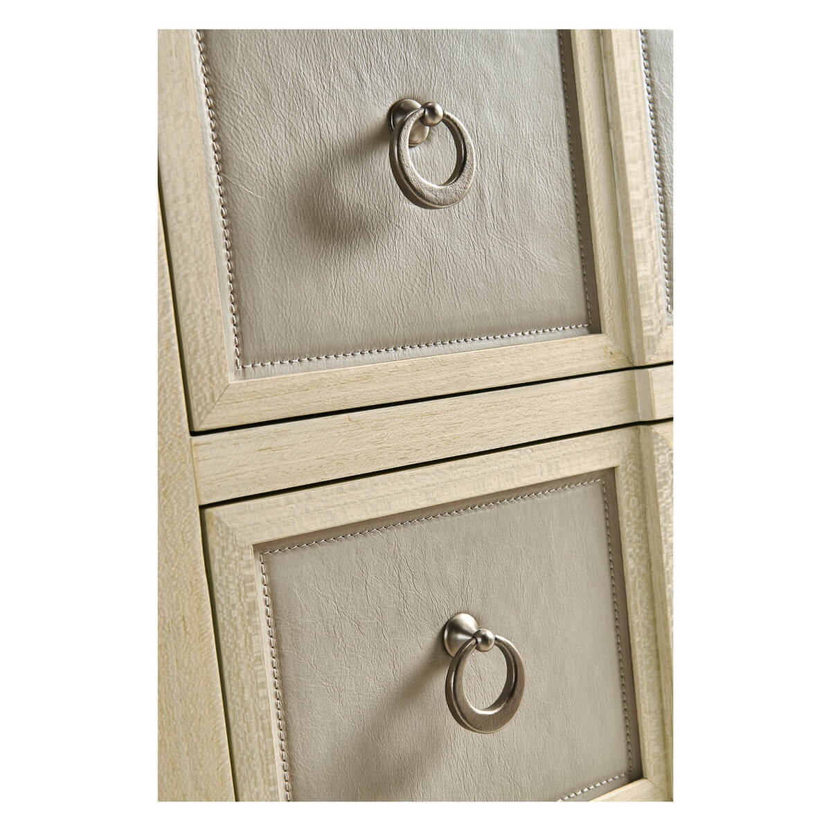 Drawer handles on leather-front chest of drawers.