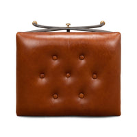 Underside view of stool, tufted leather seat focus.