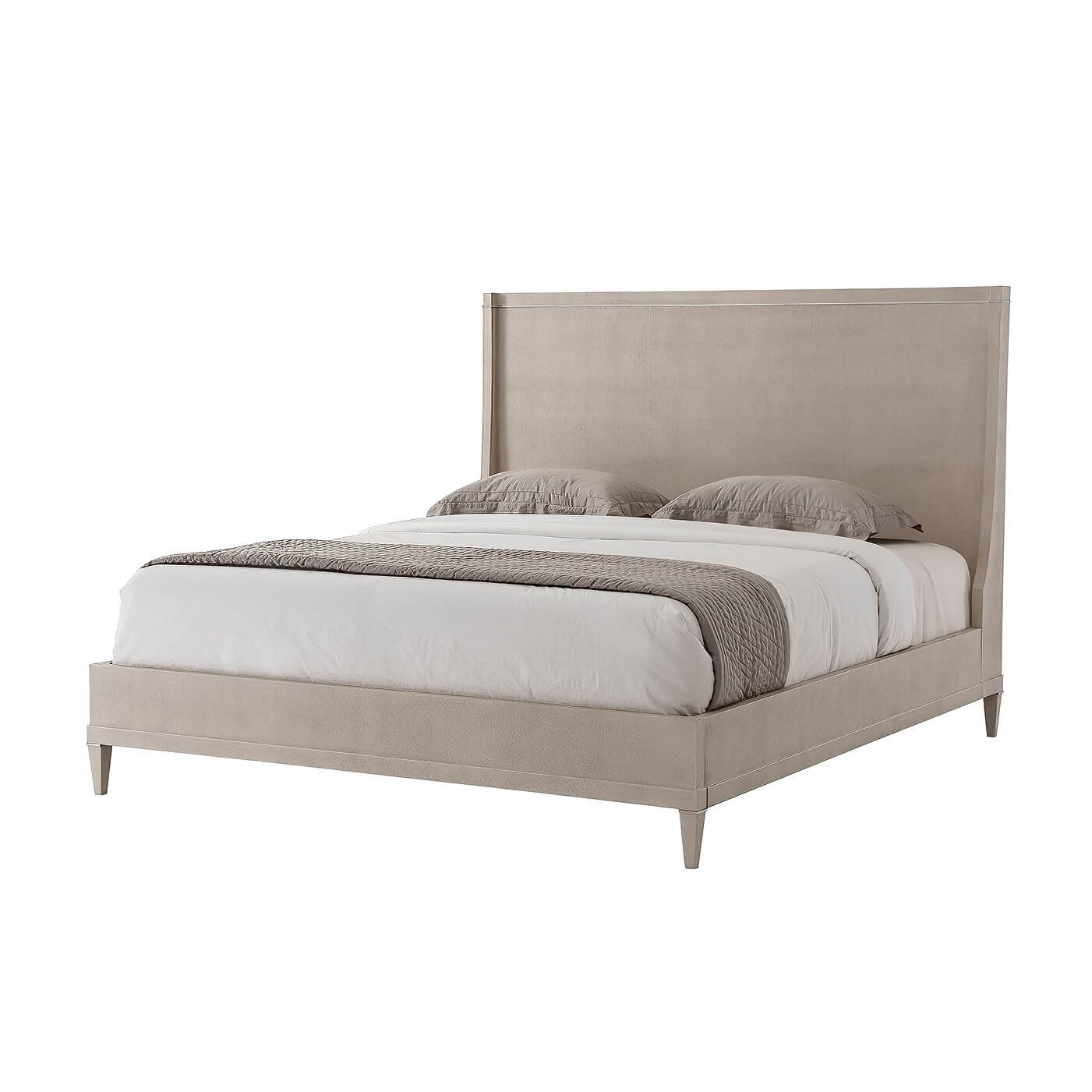 Modern leather wrapped bed with bedding, side view.