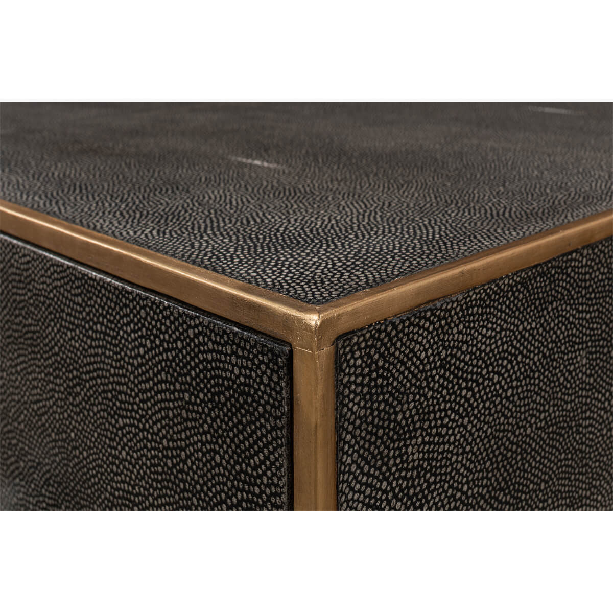 Corner close-up of dresser, textured leather and metal trim.