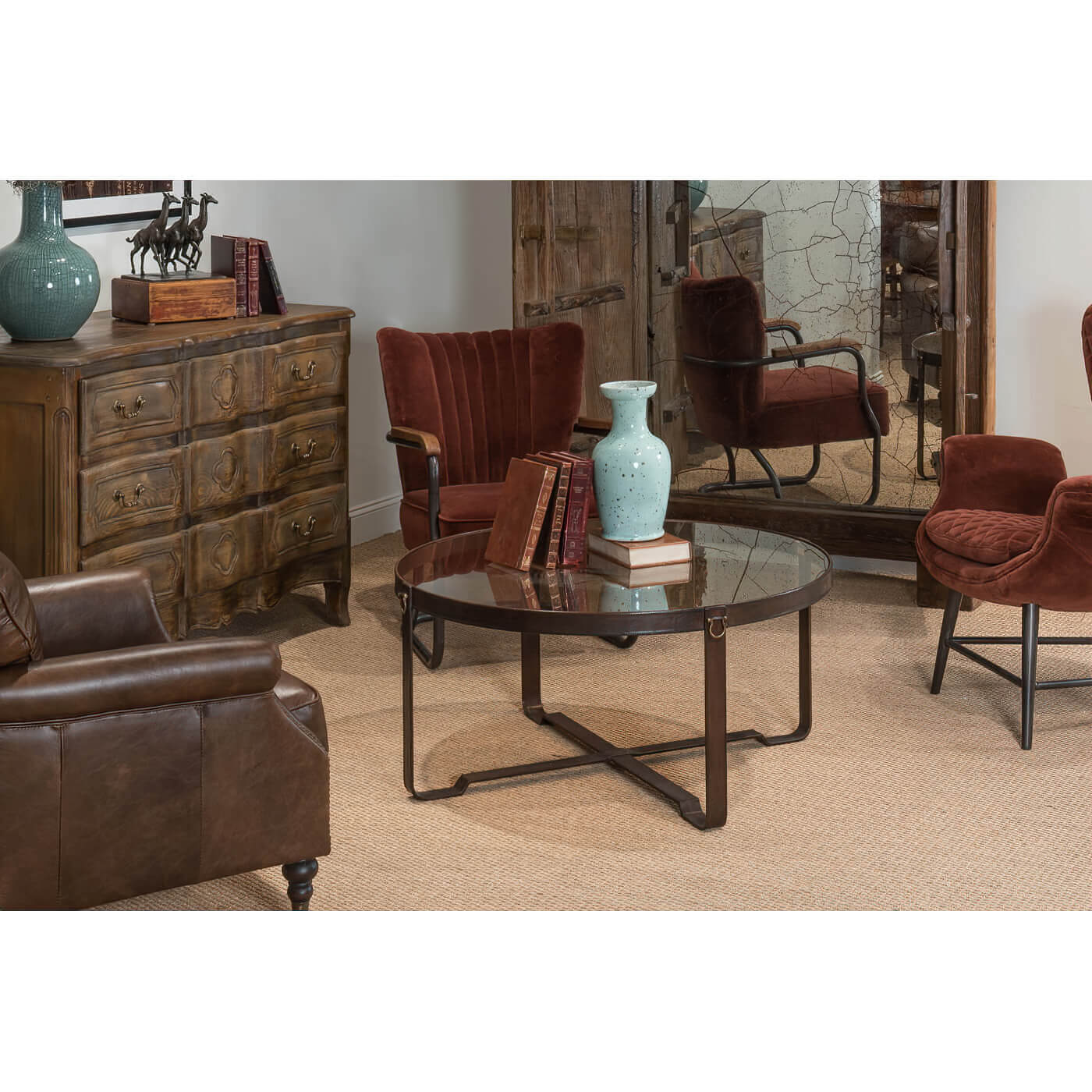 Round coffee table in living room with chairs and decor.