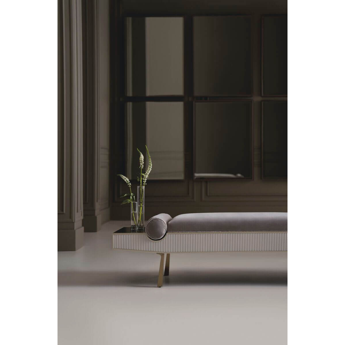 Modern luxury bench, elegant setting, dark room and plants.