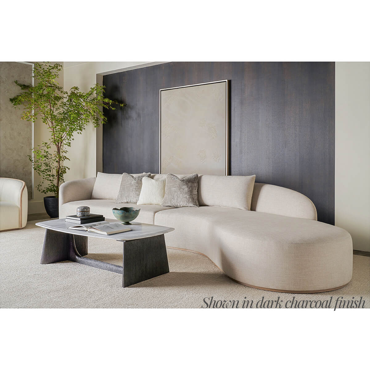 Coffee table styled with curved sofa and decor accents.
