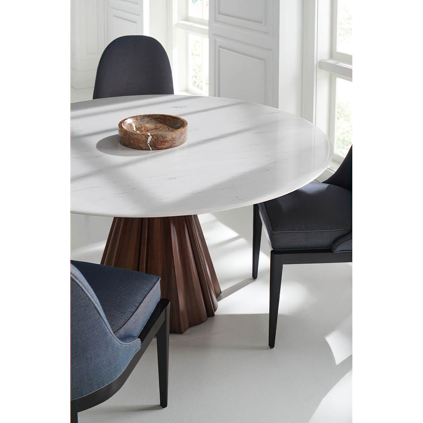 Dining table with bowl, blue chairs around.