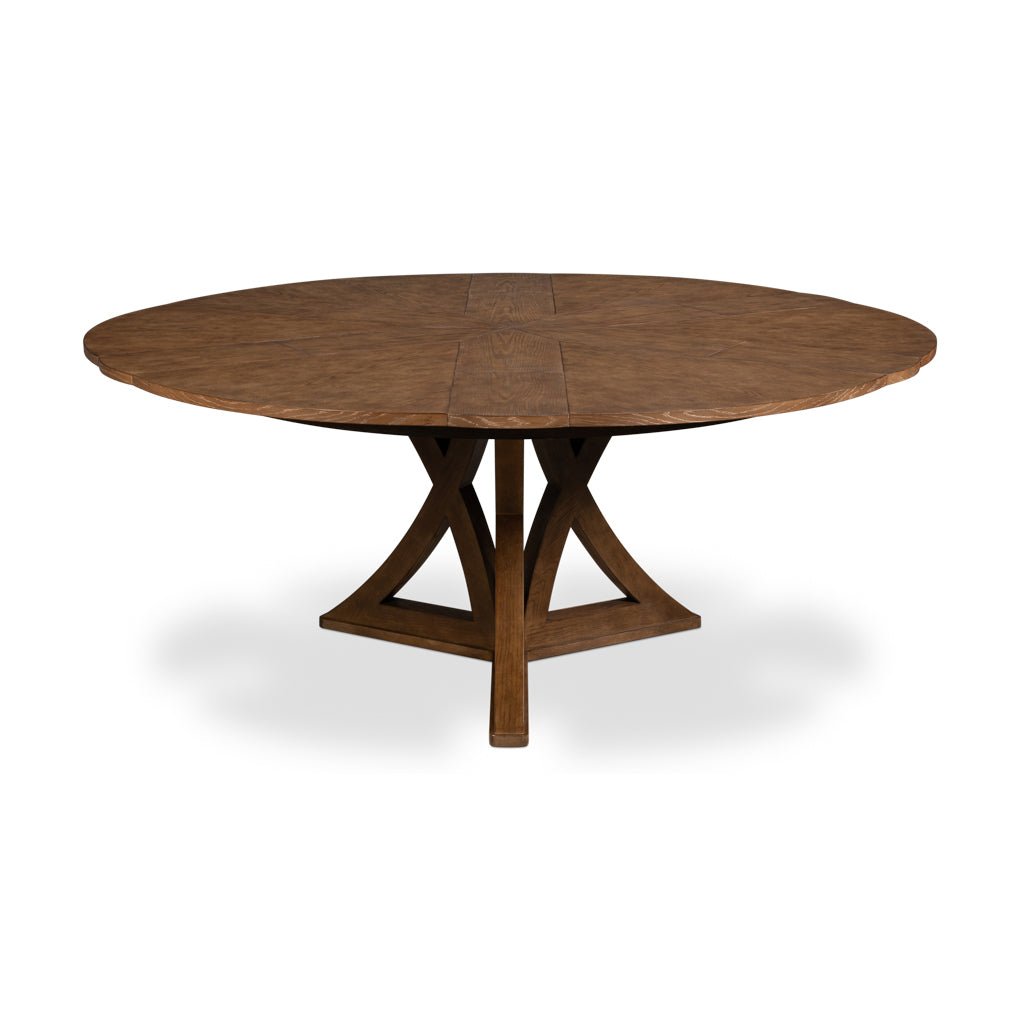 Round wooden dining table fully extended with leaf insert.