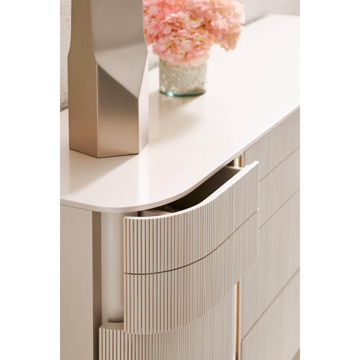 Close-up of open drawer on modern painted dresser.