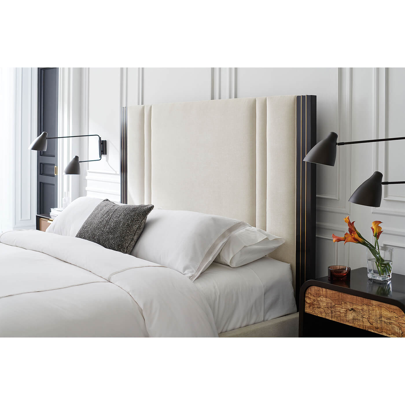 Modern king bed close-up with wall-mounted lamps.