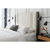 Modern king bed close-up with wall-mounted lamps.