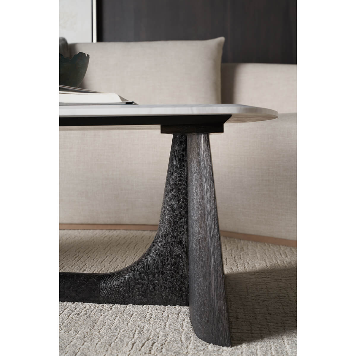 Coffee table styled with books on textured rug.
