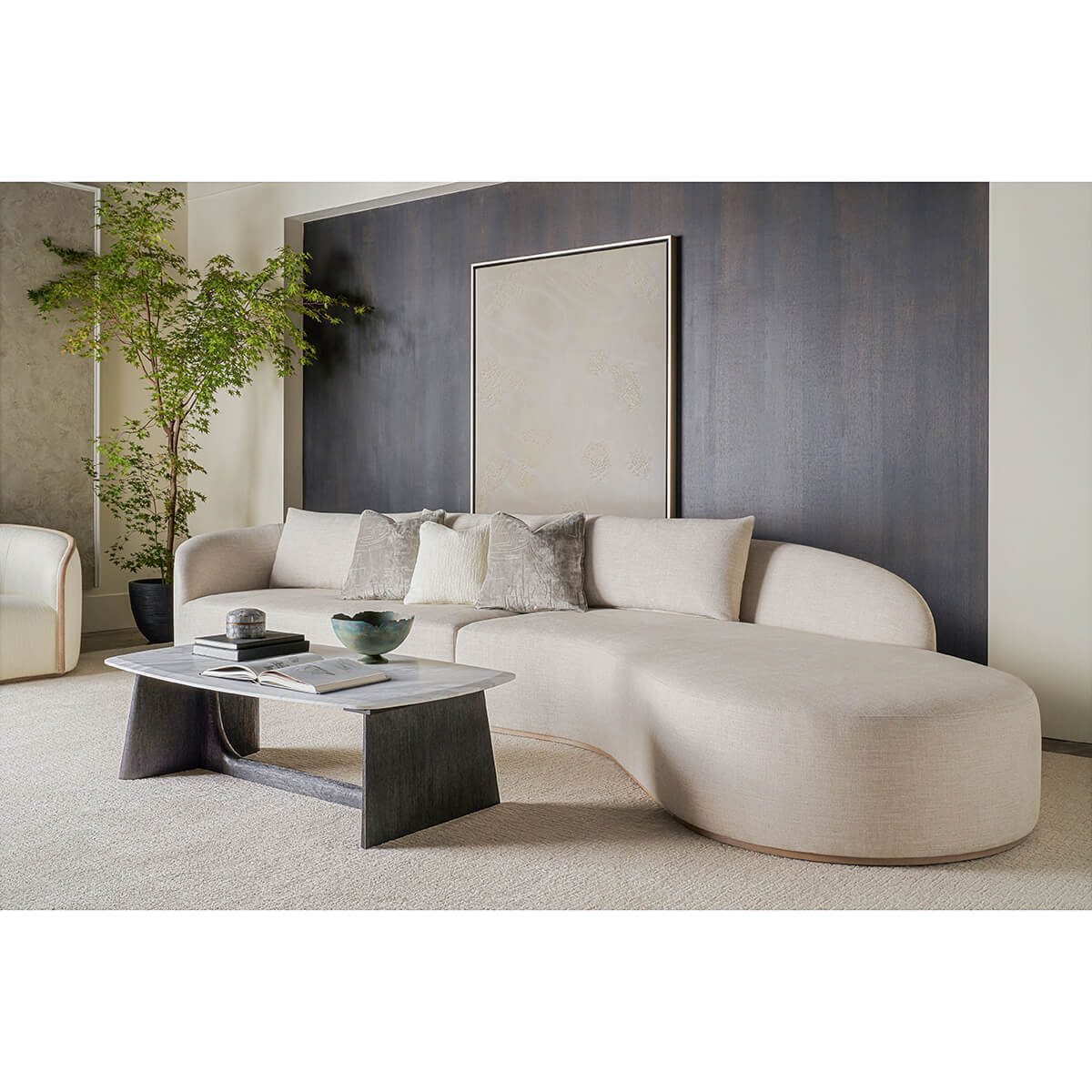 Coffee table in living room setting with curved sofa.