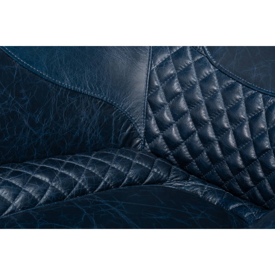 Quilted seat close-up on blue leather armchair.