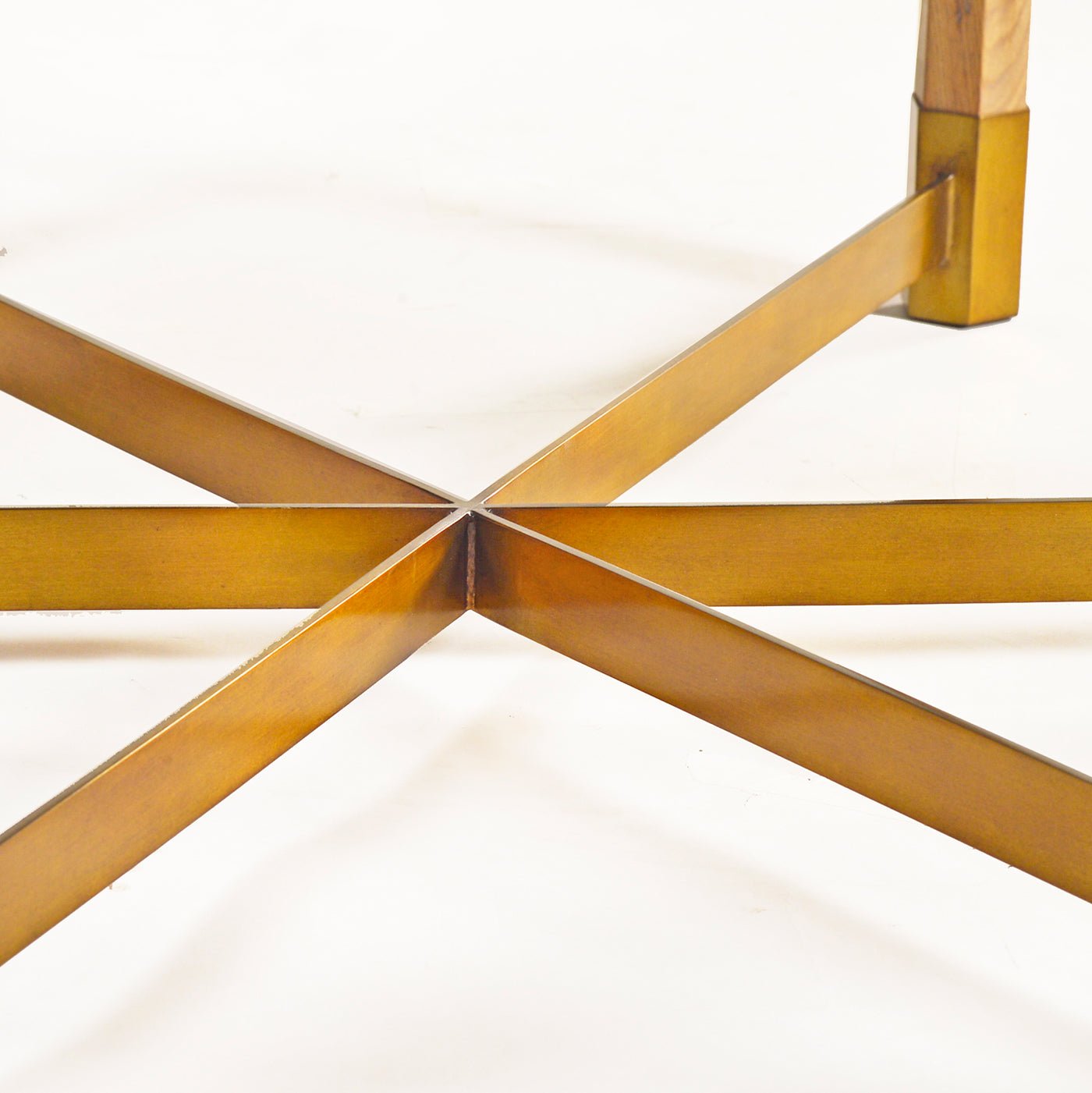Crossed metal supports under round coffee table base.
