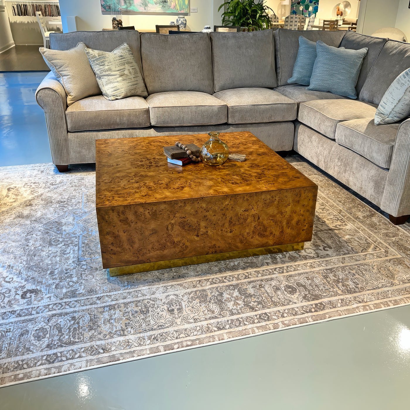 Square burl wood coffee table in living room setting.