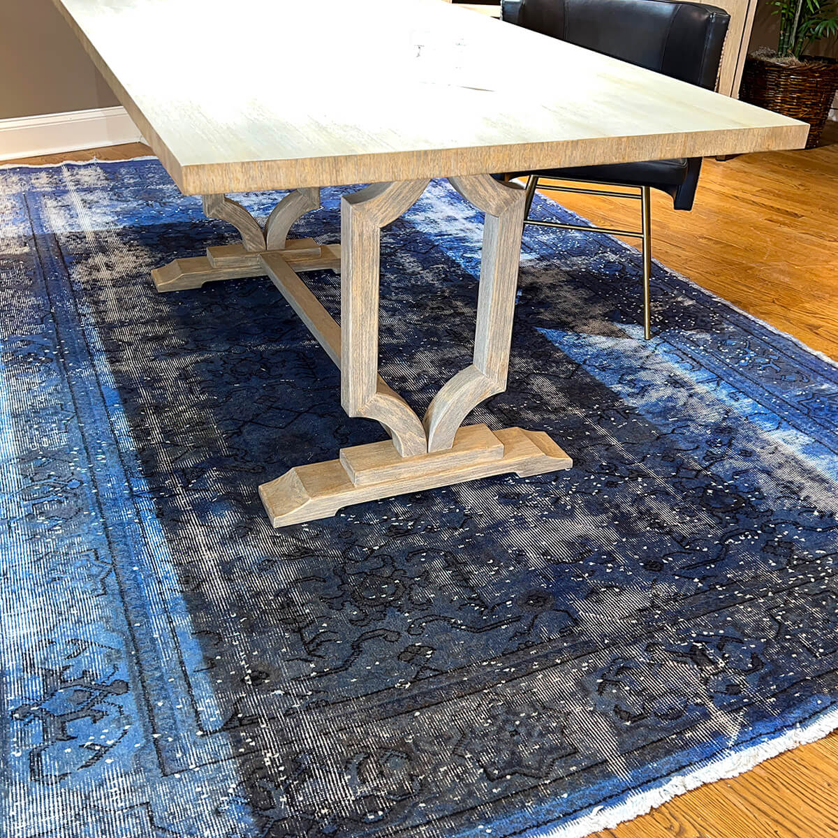 Close-up of trestle base on blue rug.