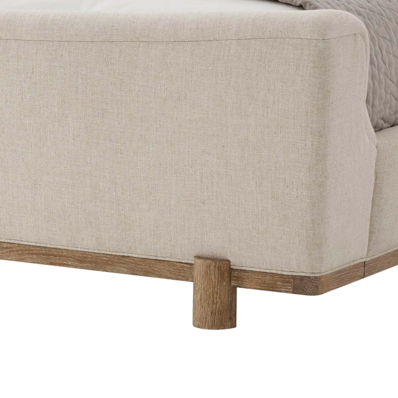 Modern upholstered bed corner with wooden leg detail.