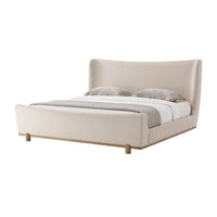 Modern upholstered king size bed with bedding, side view.