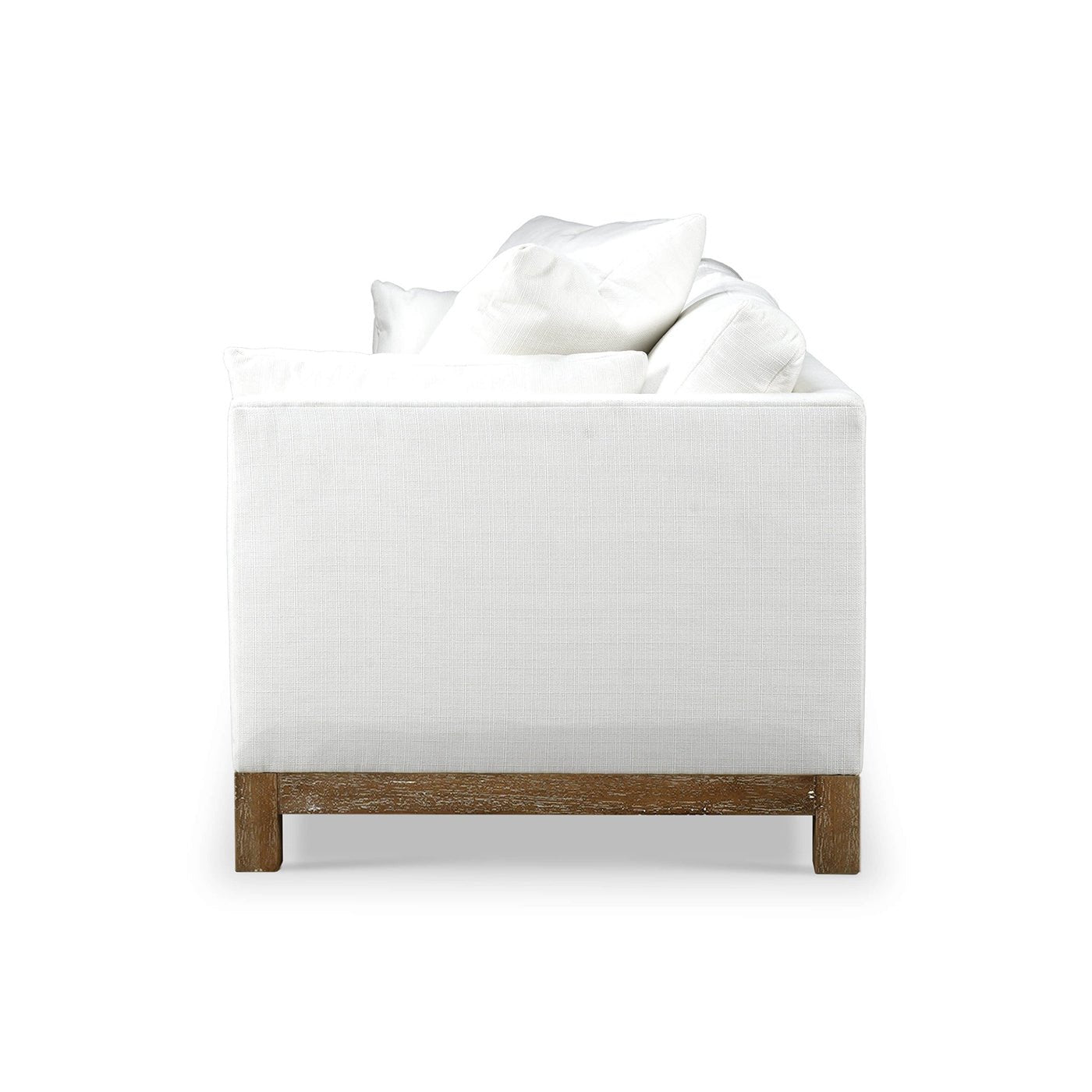 Side view of white modern sofa, pillows displayed.
