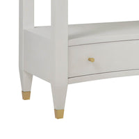 Nightstand corner detail with gold leg accents.