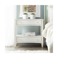 Nightstand styled in bedroom with books and plants.