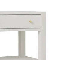 Close-up of nightstand drawer with gold knob.