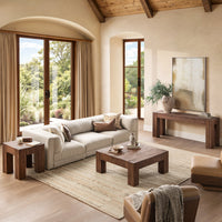 Beige modular sofa styled in a sunlit living room with a wood coffee table and exposed ceiling beams