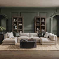 Beige U-shaped modular sectional styled with a dark coffee table against dark paneled walls