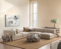 Wide room view of beige modular sectional arranged around a sculptural wood coffee table