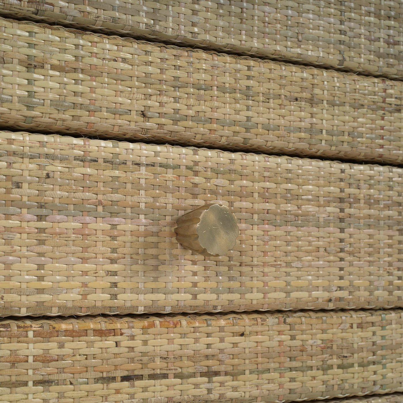Close-up of rattan drawer handle on bedside table.