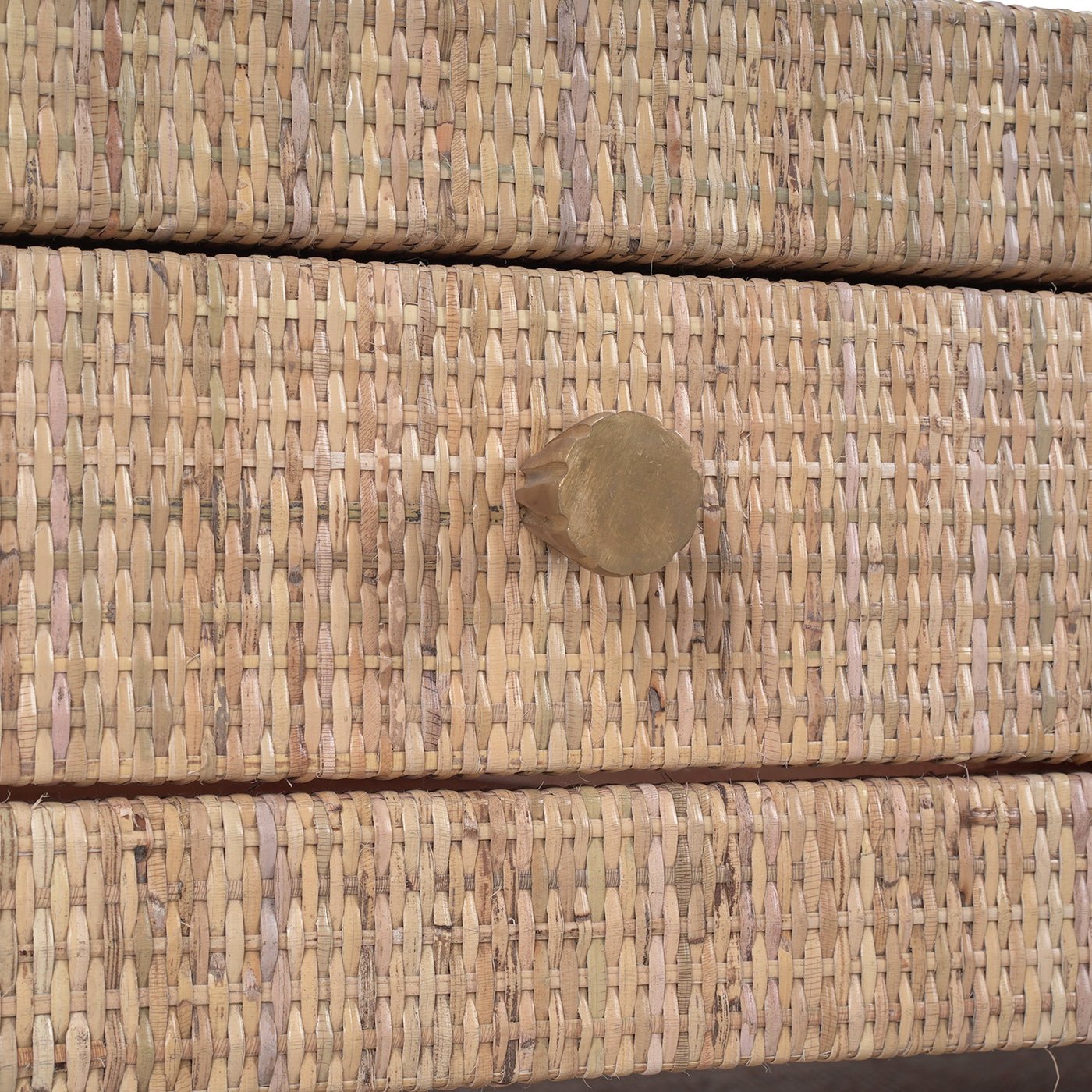 Close-up of drawer knob on natural rattan coffee table.