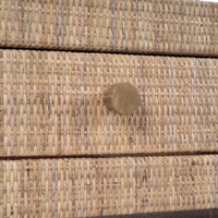 Close-up of drawer knob on natural rattan coffee table.