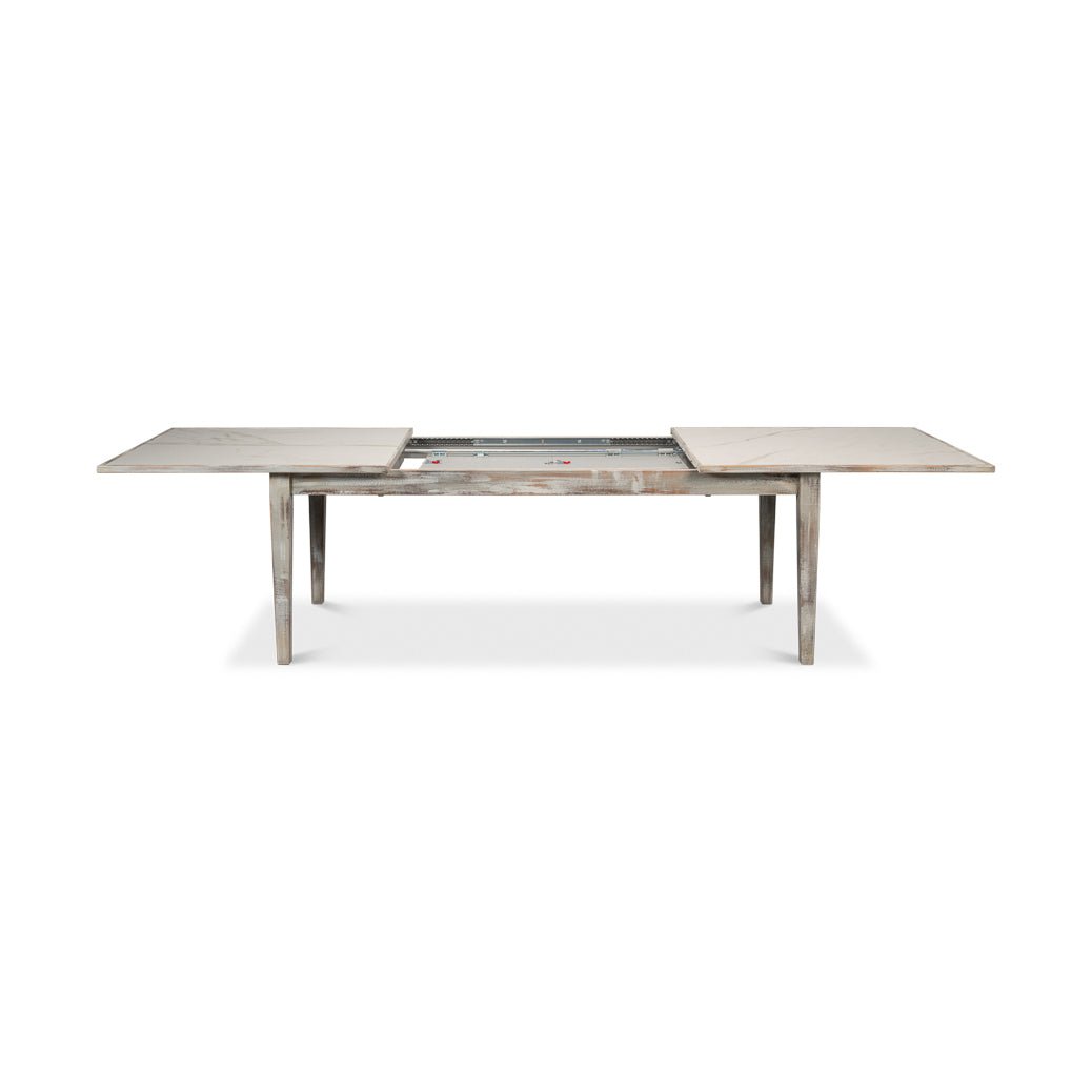 Half-extended gray painted dining table with visible mechanism.