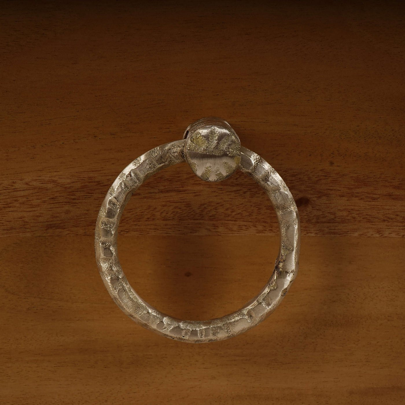 Close-up of metal ring handle on nightstand drawer.