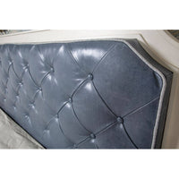 Close-up of tufted blue headboard detail.