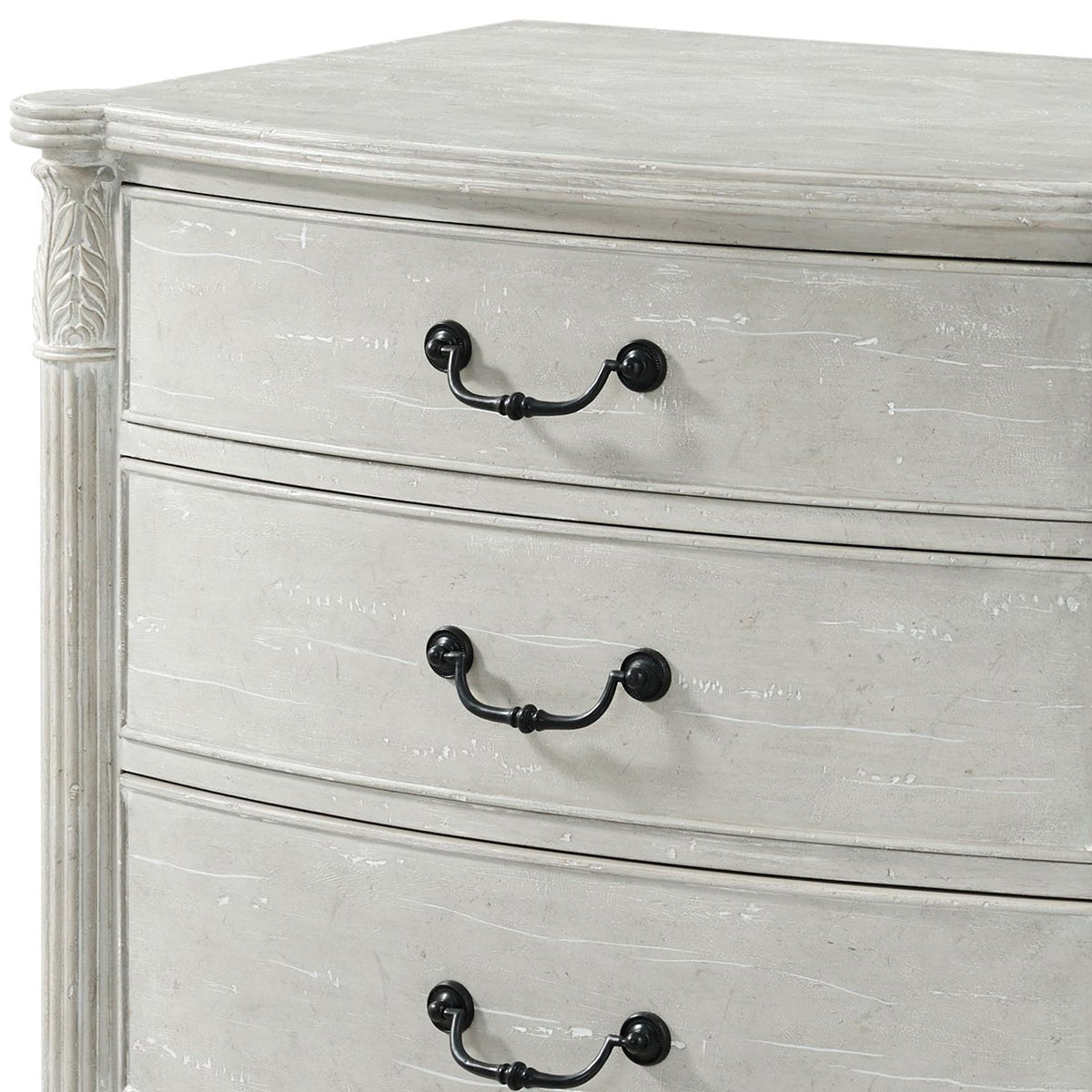 Close-up of nightstand drawer handles, carved corner detail.