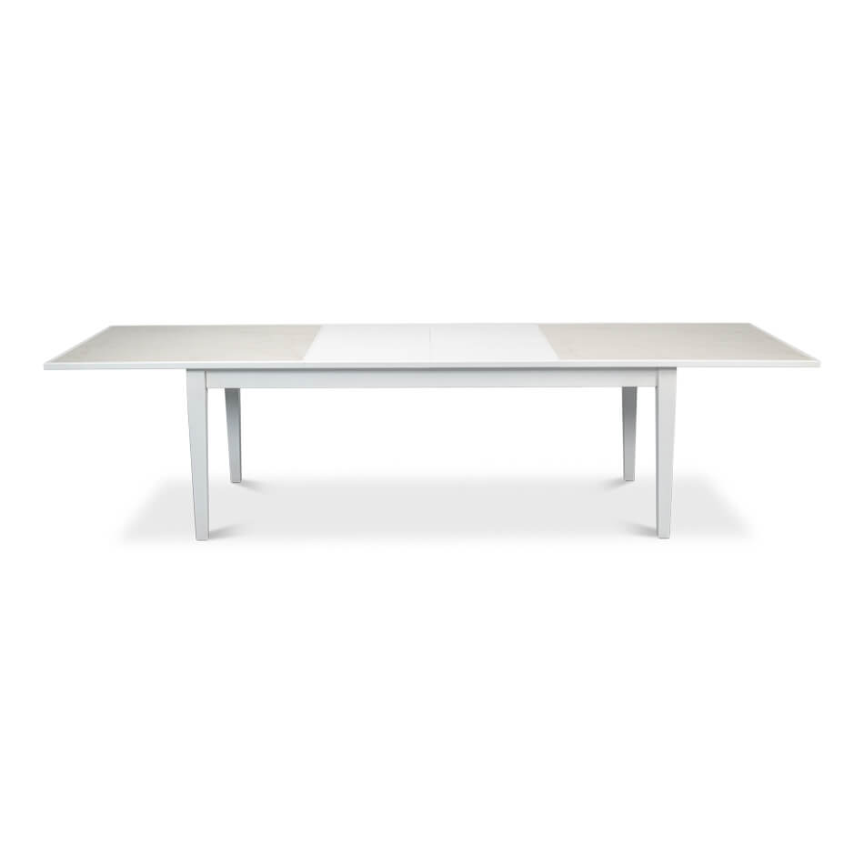 Fully extended white dining table, side perspective.