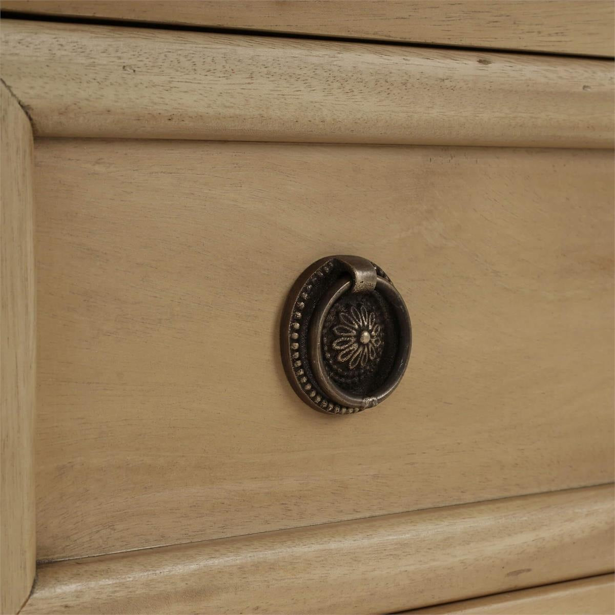 Drawer handle close-up on neoclassical nightstand.