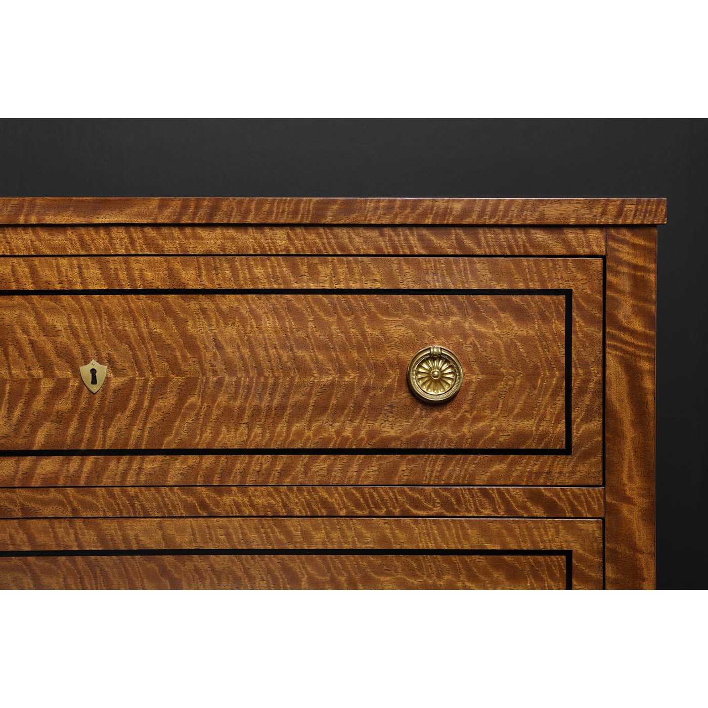 Close-up of drawer handle on commode chest.