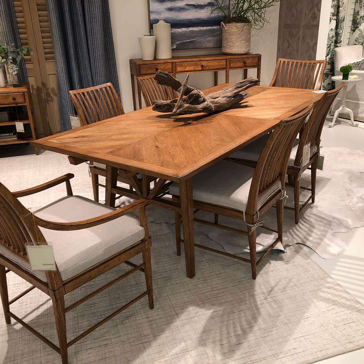 Oak dining table with chairs in a styled room.