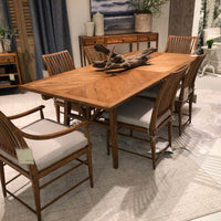 Oak dining table with chairs in a styled room.