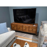 Oak media cabinet in living room, TV on top.