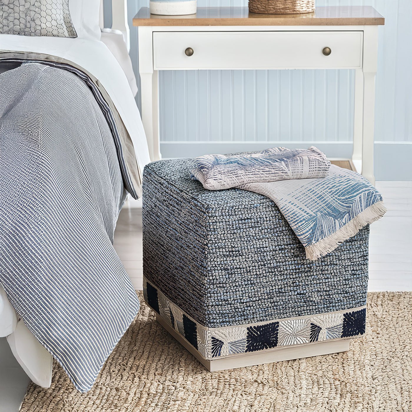 Blue cube ottoman in bedroom setting with accessories.