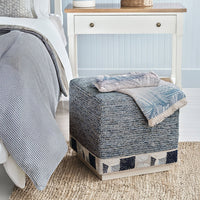 Blue cube ottoman in bedroom setting with accessories.